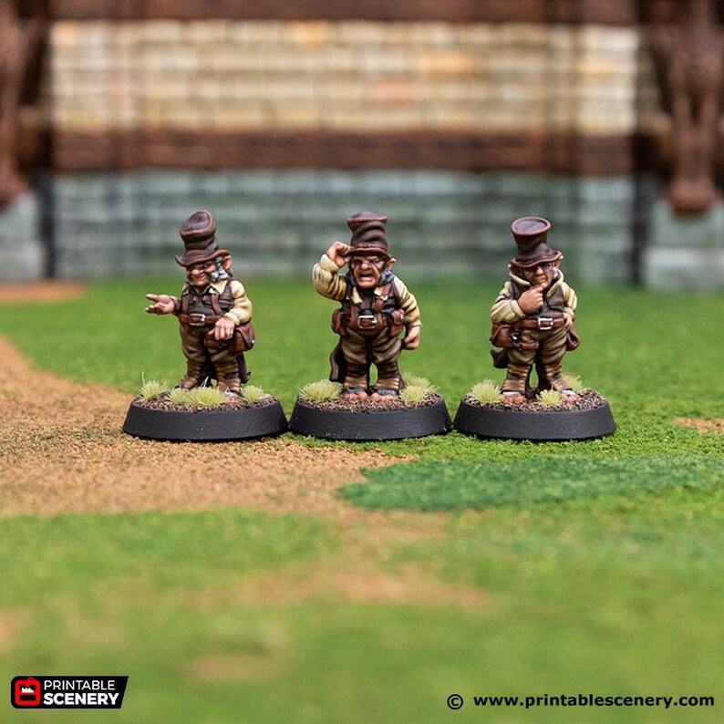 May include: Three miniature figures of goblins wearing brown hats and brown and tan clothing. The figures are standing on black bases.