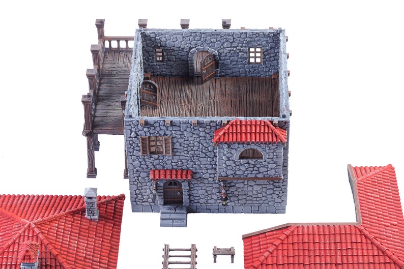 May include: A grey stone building with a red tiled roof and a wooden balcony. The building is made of several pieces that can be assembled to create a miniature model.
