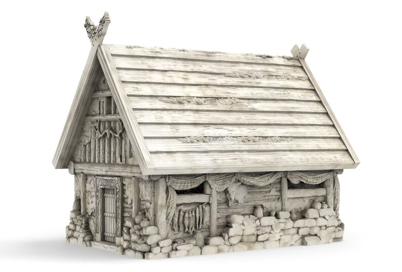 Op de afbeelding: Een wit houten Vikinghuis met een rieten dak, een stenen fundering en een deur. Het huis heeft een raam met een netgordijn en een visdroger die buiten hangt.