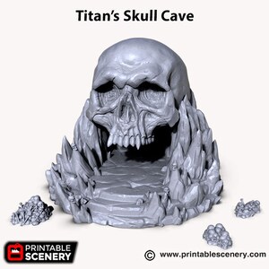May include: A 3D printed model of a skull cave, with a large skull forming the entrance. The cave is surrounded by jagged rock formations and smaller skulls. The model is painted in a light gray color.