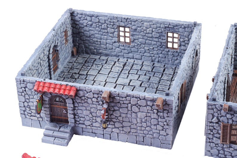 May include: A grey stone building with a red roof, a wooden door, and two windows. The building is a miniature model for tabletop gaming.