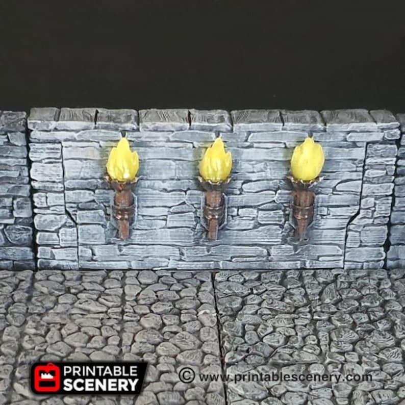 May include: Three wall-mounted torch sconces with yellow flames, mounted on a gray stone wall. The sconces are made of brown metal and have a simple design.