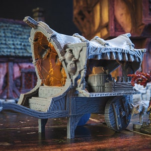 May include: A grey wooden wagon with a canvas top and a wooden barrel inside. The wagon has two wheels and a long tongue. The wagon is sitting on a wooden surface.