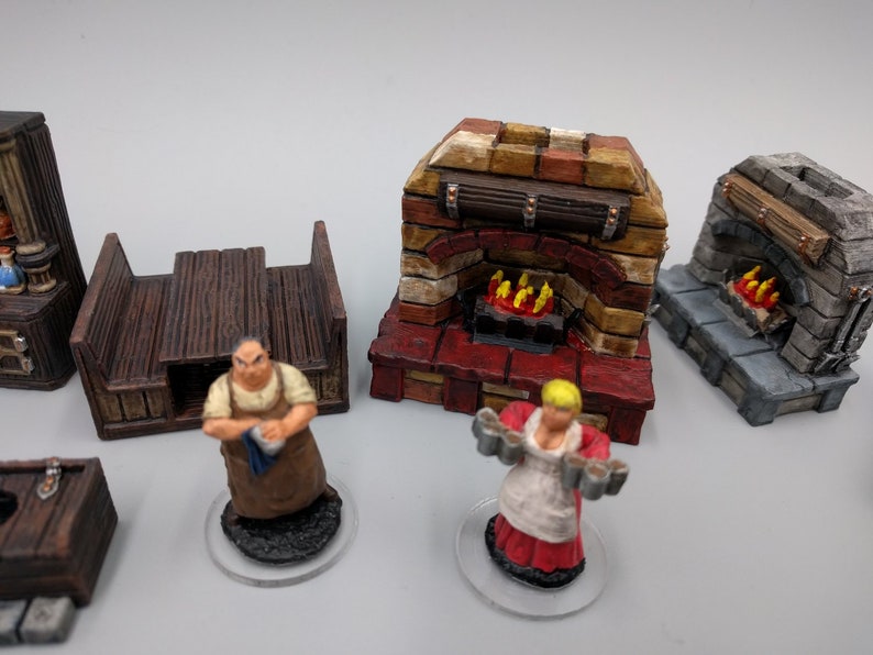 May include: Two painted miniature figures of people, one holding a tray of mugs and the other holding a cloth.  There are three miniature painted structures, two are brick fireplaces with a wood mantle and the other is a stone fireplace with a wood mantle.  All are painted in realistic colours.
