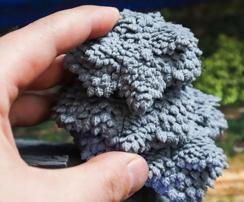 Puede incluir: Un conjunto de dos piezas de follaje impresas en 3D de color gris, que se asemejan a un arbusto o un &aacute;rbol peque&ntilde;o. Las piezas est&aacute;n hechas de un material texturizado que se asemeja a hojas.