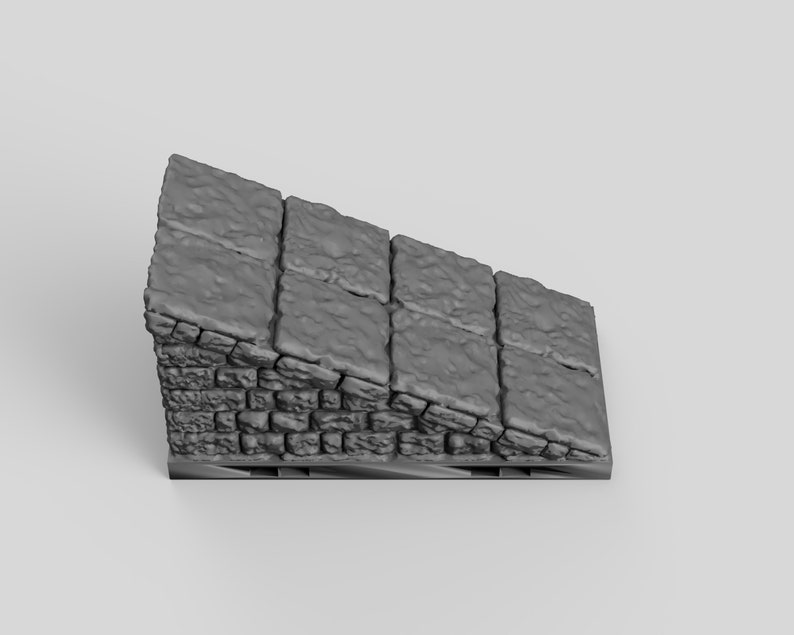 May include: A gray, textured, stone ramp with a rough, uneven surface. The ramp is made of small, rectangular stones and is angled upwards.