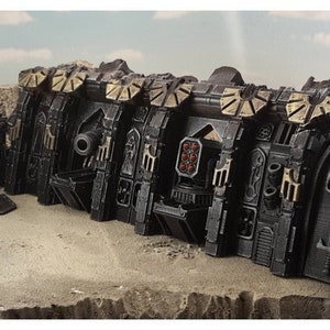 May include: A black and gold plastic model of a fortified wall with multiple gun turrets and a skull design. The wall is made up of several sections that can be connected together.