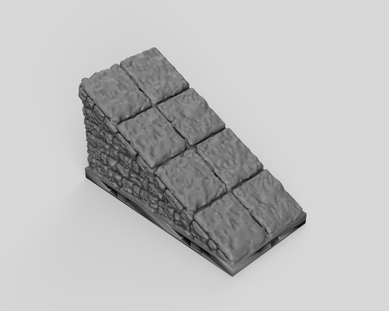 May include: A gray, textured, stone-like ramp made of stacked blocks. The ramp is on a wooden pallet.