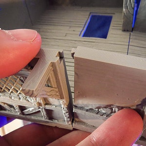 Puede incluir: Primer plano de dos piezas de un modelo impreso en 3D, mostrando una costura &aacute;spera y sin terminar donde las piezas se unen. El modelo es de color marr&oacute;n claro y tiene una superficie texturizada.