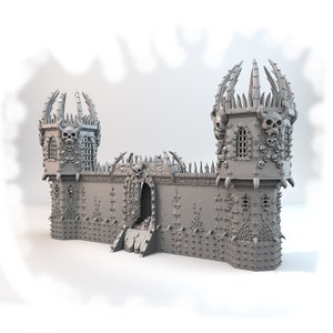 May include: A gray 3D printed model of a gothic castle with two towers, a large gate, and a wall covered in skulls and spikes.