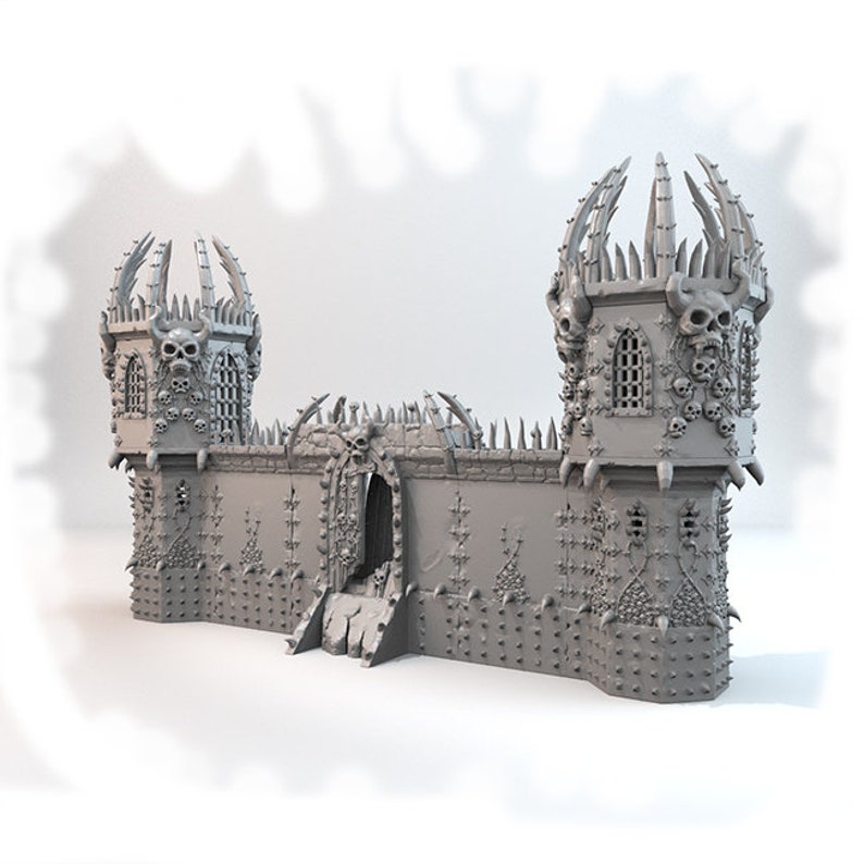 May include: A gray 3D printed model of a gothic castle with two towers, a large gate, and a wall covered in skulls and spikes.