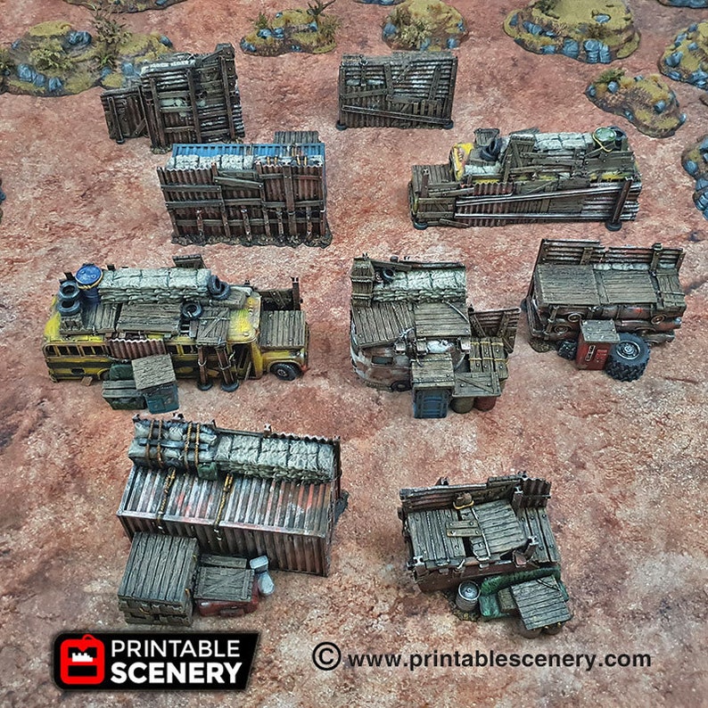 May include: A collection of 3D printed, hand-painted, miniature buildings and vehicles made from resin. The buildings are made to look like they are made from scrap metal and wood. The vehicles are a bus and a truck. The buildings and vehicles are all on a brown surface.  Printable Scenery www.printablescenery.com