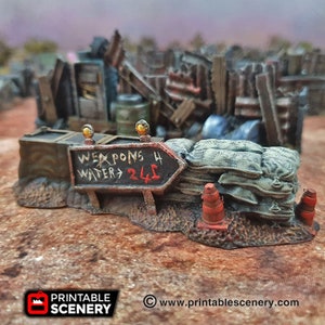 May include: A miniature model of a barricade with a sign that reads "Weapons 4 Water 24$". The barricade is made of wood, sandbags, and traffic cones. The sign is painted in black and white with red accents.