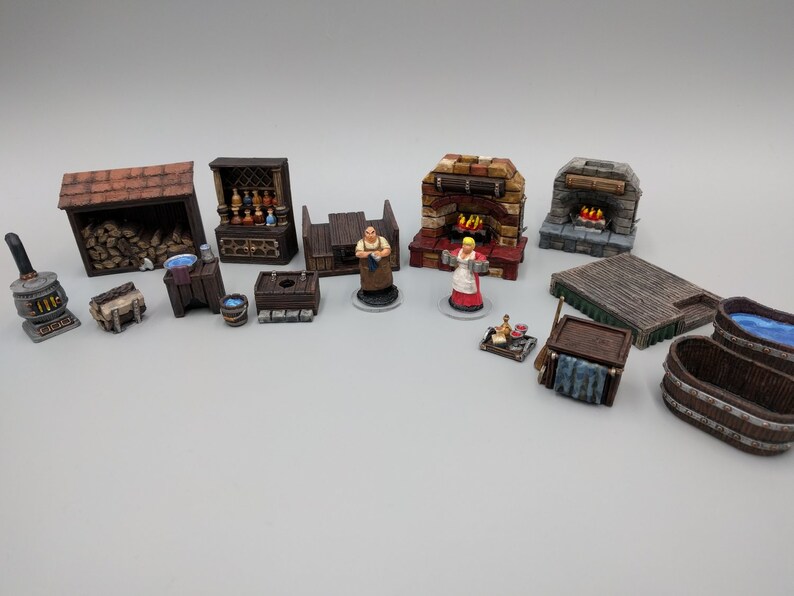 May include: A collection of miniature wooden furniture and figures for tabletop gaming. The set includes a fireplace, a bar, a woodpile, a table, a stool, a tub, and two figures. The figures are a man and a woman, both wearing medieval clothing.