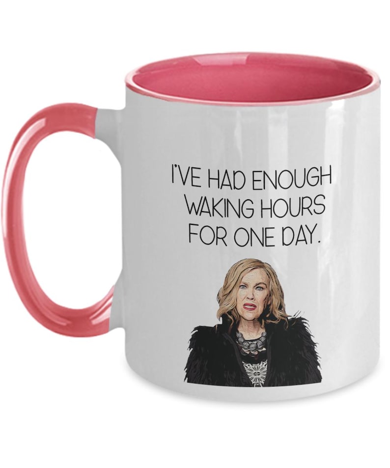 May include: White ceramic mug with a pink interior and handle. The mug features the text "I'VE HAD ENOUGH WAKING HOURS FOR ONE DAY." and an illustration of a woman with blonde hair and a black jacket.