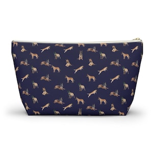 May include: A navy blue zippered pouch with a repeating pattern of brown and tan German Shepherd dogs in various poses.
