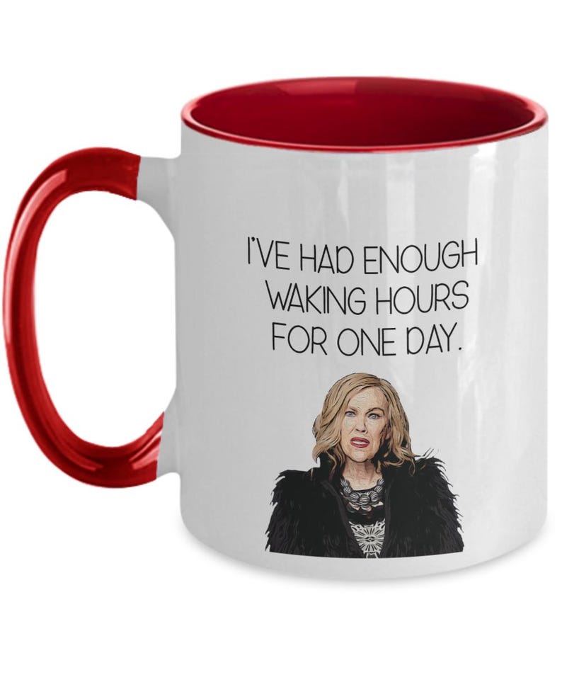 May include: White ceramic mug with a red interior and handle. The mug features the text "I'VE HAD ENOUGH WAKING HOURS FOR ONE DAY" and an illustration of a woman with blonde hair and a black jacket. A humorous gift.