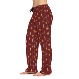 May include: Red pajama pants with a repeating pattern of kangaroos. The pants have a drawstring waistband.
