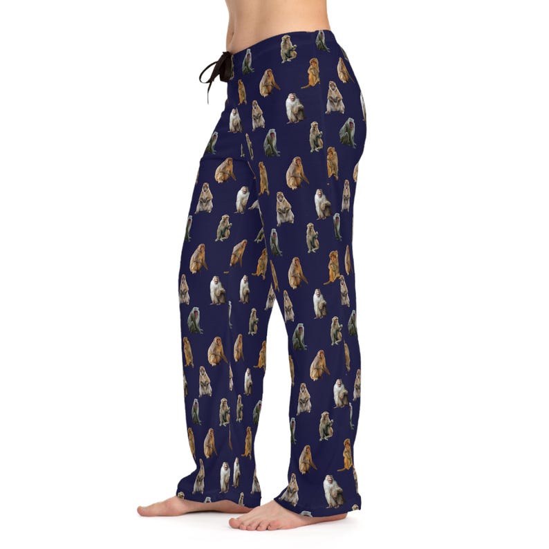May include: Navy blue pajama pants with a repeating pattern of various monkey illustrations in shades of brown, gray, and green. The pants have a drawstring waist.
