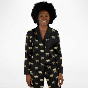 以下が含まれることがあります： 羊のプリントが施された黒いパジャマセット。トップスは襟付きで長袖。パンツはゴムウエストです。