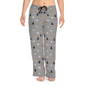 Peut inclure: Pantalon de pyjama gris avec un motif répété de différentes races de chiens. Le pantalon a une taille élastique avec un cordon de serrage noir.