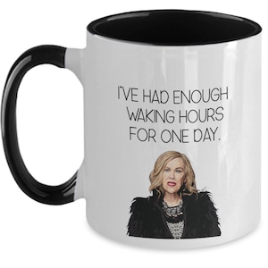 May include: White ceramic mug with a black interior and handle. The mug features the text "I'VE HAD ENOUGH WAKING HOURS FOR ONE DAY." and an illustration of a woman.