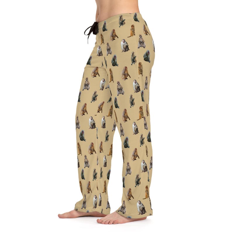 May include: Tan pajama pants with a repeating pattern of various monkey illustrations in shades of brown, gray, and white. The pants have a drawstring waist and a relaxed fit. The pajama pants are made of a soft material.