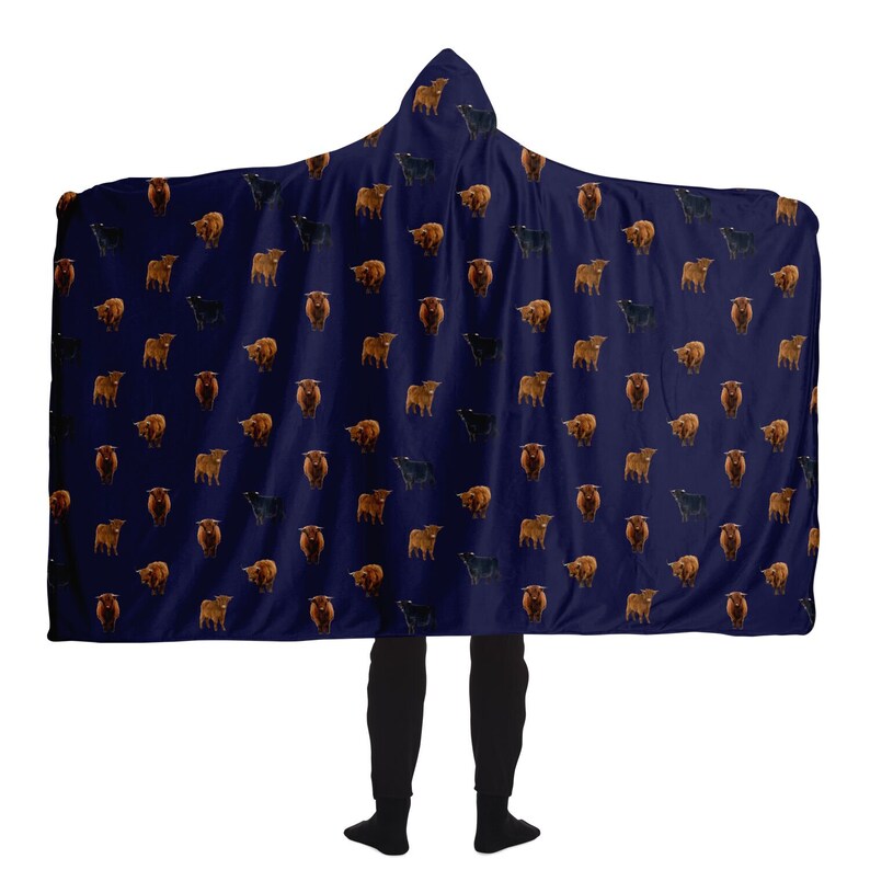 May include: A navy blue hooded blanket with a repeating pattern of brown and black Highland cattle. The blanket is large enough to cover a person from head to toe.