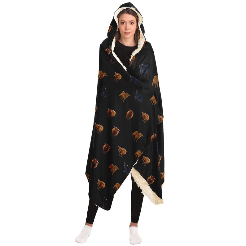May include: A black hooded blanket with a white sherpa lining. The blanket features a repeating pattern of brown and black bulls.