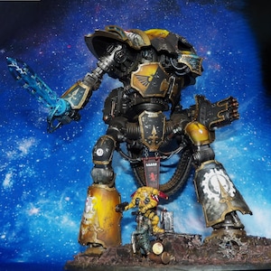 May include: A yellow and black painted robot with a blue sword, standing on a rocky base with smaller robots. The robot has a large, detailed design and is a popular collectible for fans of science fiction and fantasy.