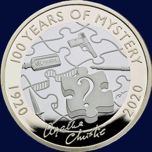 Puede incluir: Una moneda de plata que conmemora 100 años de misterio, con piezas de rompecabezas, una pistola, una botella de veneno, un cuchillo y un bolígrafo. La moneda incluye el texto "1920" y "2020", y la firma "Agatha Christie".