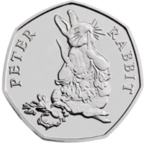 May include: A silver 50 pence coin with a heptagonal shape. The coin features an image of Peter Rabbit, with the words "PETER RABBIT" around the edge. Peter Rabbit is holding a sprig of vegetables.