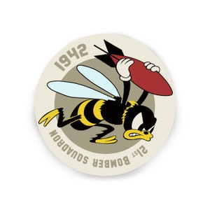 May include: A round, beige sticker with a black and yellow cartoon bee carrying a red bomb. The bee is flying and has an angry expression. The text "21st BOMBER SQUADRON 1942" is written around the bee.