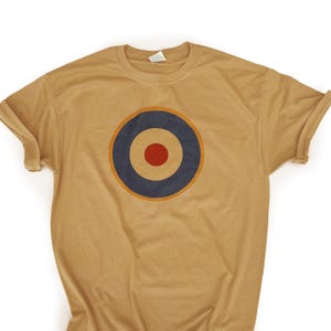 May include: A tan t-shirt with a vintage-style red, white, and blue target graphic printed on the front.