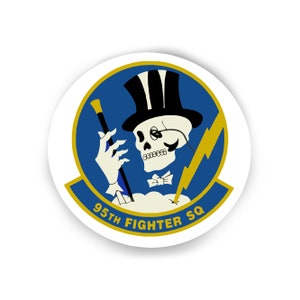 May include: A blue and gold round sticker with a skeleton wearing a top hat and monocle, holding a cane. The text "95th Fighter SQ" is written in gold below the skeleton.