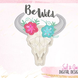 Può includere: Disegno ricamato con un teschio bianco con corna, decorato con fiori rosa e blu. Il testo "Be Wild" è sopra il teschio.