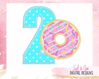 May include: A digital illustration featuring the number "2" in light blue with white polka dots, next to a pink frosted donut with sprinkles. The donut has a tan-colored center and is decorated with pink, blue, and yellow sprinkles. The design is set against a white background.