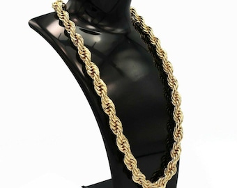May include: A gold-colored rope chain necklace displayed on a black jewelry bust. The chain has a thick, twisted design, and the bust is set against a white background. The necklace is a bold statement piece.