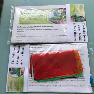 Könnte beinhalten: Ein Set aus Chakra-Seiden in Rot, Orange, Gelb, Grün und Blau, mit Anweisungen für eine Farbchakra- und Aura-Heilungs-Sitzung. Das Paket enthält ein Pendel. Der Text lautet "Performing a Colour Chakra & Aura Healing."