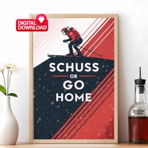 May include: A framed print with a skier in red and black, skiing down a snowy slope. The text "SCHUSS OR GO HOME" is displayed in white. A "DIGITAL DOWNLOAD" sticker is in the upper left corner.