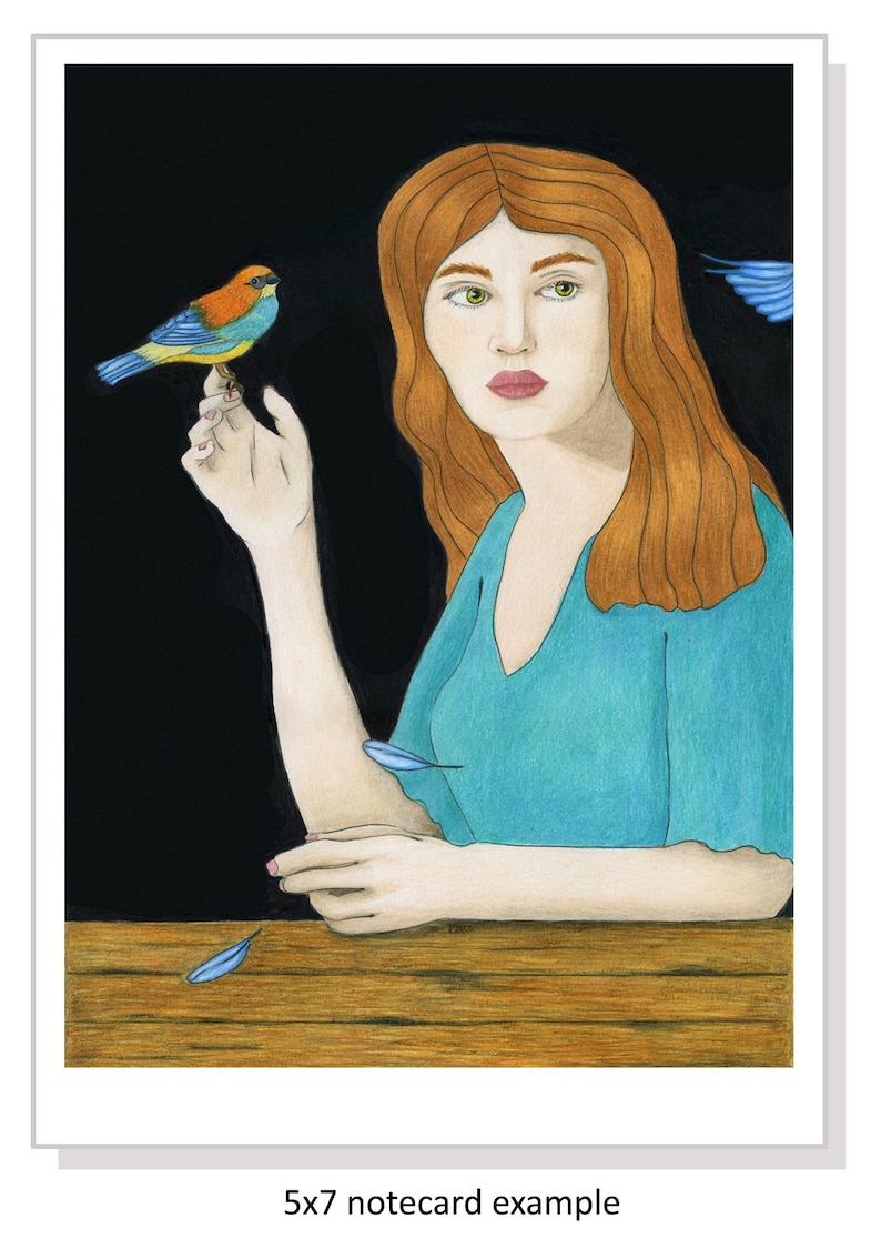 May include: A woman with long, red hair sits at a table with a small blue bird perched on her finger. The background is black, and there are blue feathers scattered on the table.