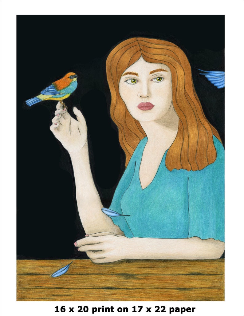 May include: A woman with long, red hair sits at a wooden table. She is wearing a teal blue dress and holding a small, colorful bird in her hand. There are blue feathers scattered on the table.