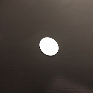 May include: A white circle sticker on a black surface.