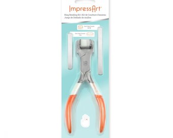 Könnte beinhalten: Ein silbernes Ringbiegewerkzeug mit orangefarbenen Griffen und zwei Metallmesslehren. Das Werkzeug ist auf einem blau-weißen Hintergrund verpackt mit dem Text "Impress Art" und "Ringbiege-Set".