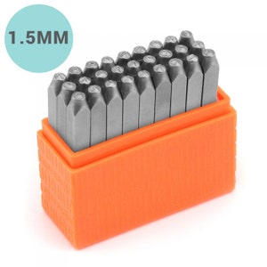 Pode incluir: Um conjunto de 36 carimbos de letras e números de metal em uma caixa de plástico laranja. Os carimbos têm 1,5 mm de tamanho.