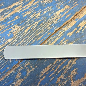 May include: A silver metal nameplate with rounded edges. The nameplate is blank and ready to be engraved.