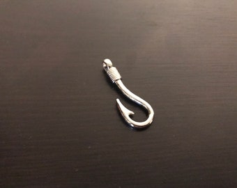 May include: A silver-toned metal fishing hook charm. The hook is curved and has a small eye at the top.