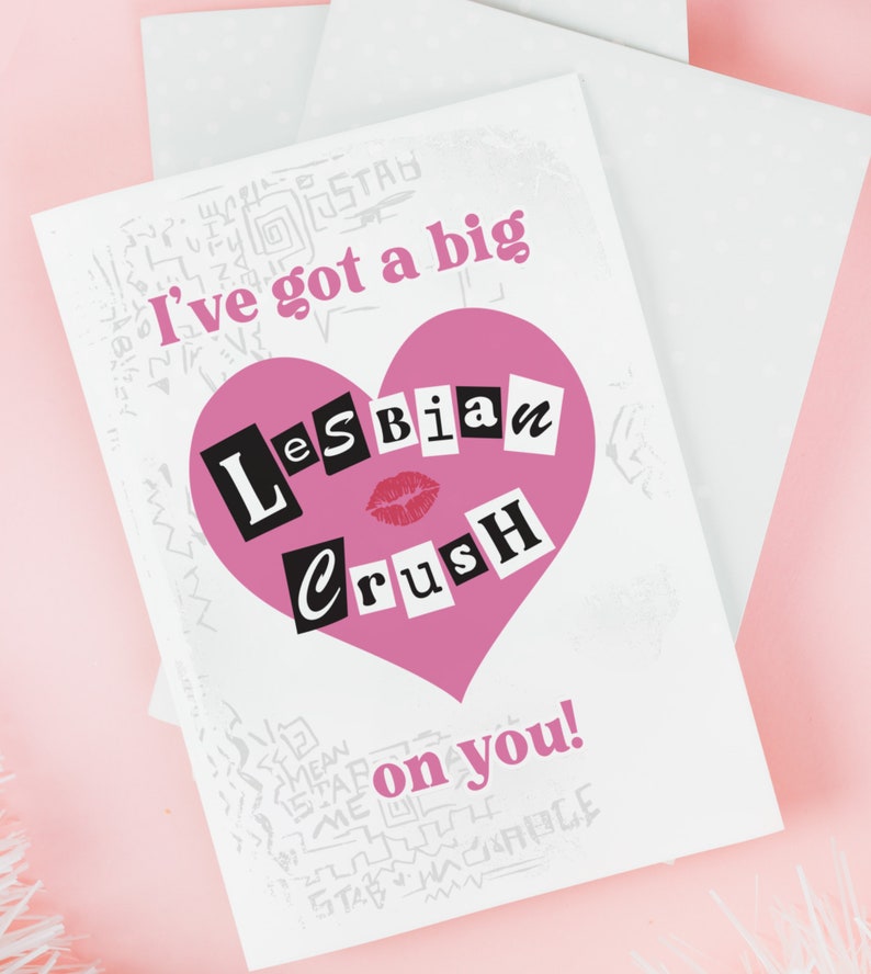 May include: A white card with a pink heart that says "Lesbian Crush" in black block letters. The card has the text "I've got a big" above the heart and "on you!" below the heart.