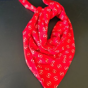 May include: A red bandana with a white pattern of crescent moons and stars.