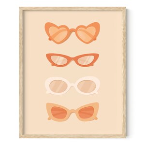 May include: Four pairs of sunglasses in different styles and colours. The sunglasses are arranged vertically, with the top pair being heart-shaped, the second pair being cat-eye, the third pair being round, and the fourth pair being a more classic style. The background is a light peach colour.
